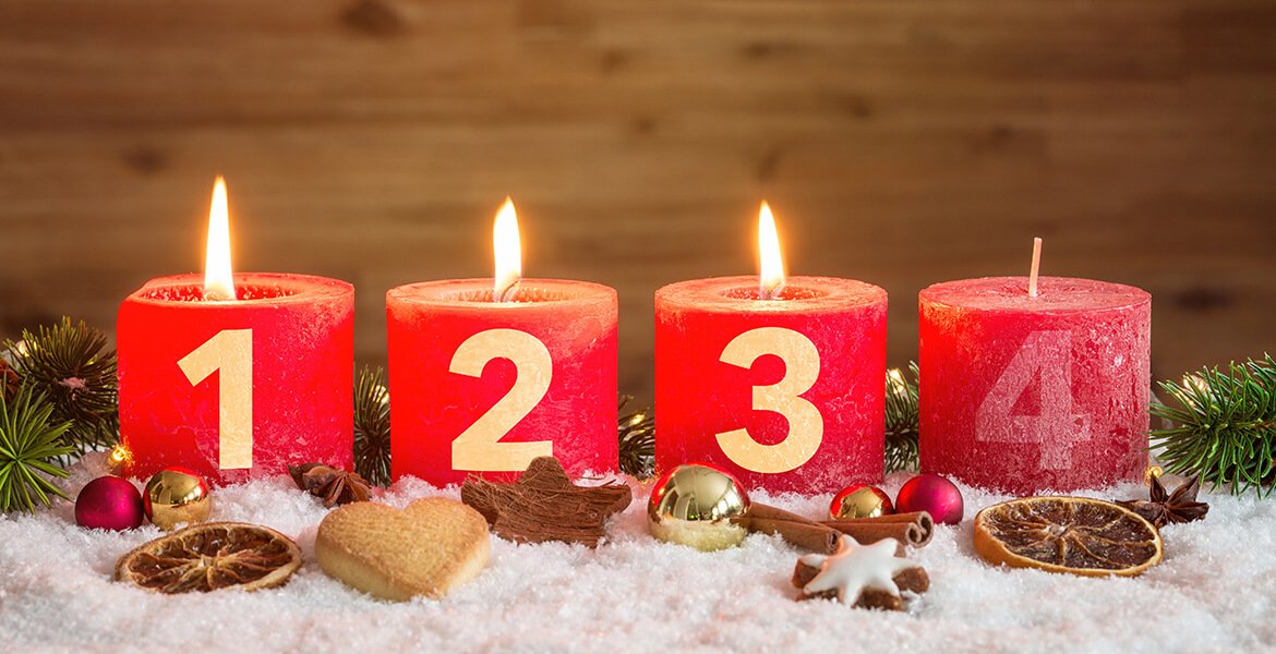 Vier rote nummerierte Adventskerzen mit dritter Kerze angezündet und Weihnachtsdekoration in Schnee als Vorlage